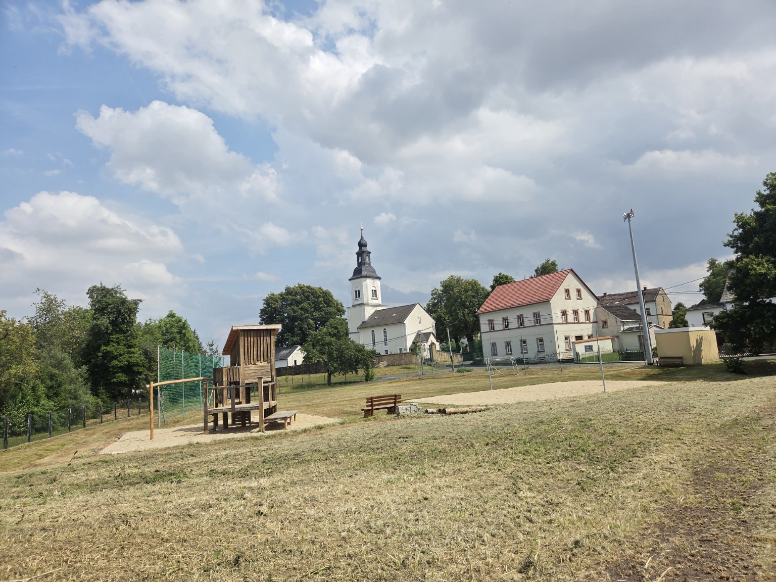 Blick auf Nauenhain mit Kirche und Spielplatz